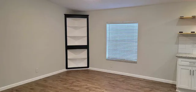 an empty room with wooden floor and closet