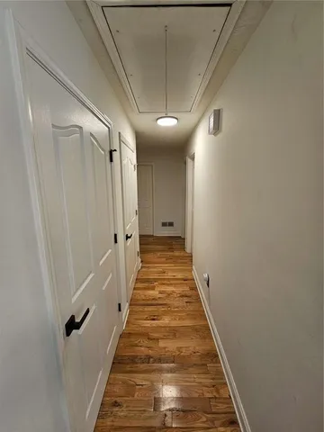 a view of a hallway with wooden floor and staircase
