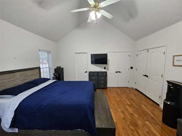 a bedroom with a bed and a flat tv screen on the dresser