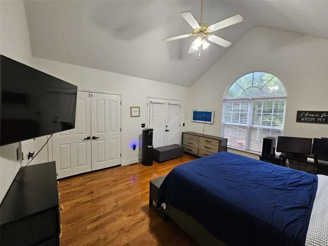 a spacious bedroom with a bed and a flat screen tv