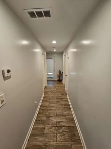 a view of a hallway with wooden floor and a hallway