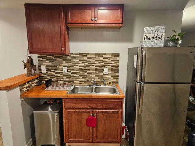 a view of a kitchen with a sink and a refrigerator