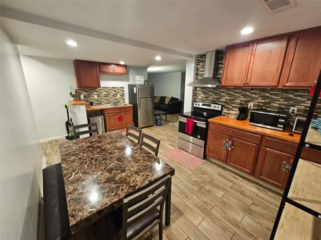 a kitchen with stainless steel appliances granite countertop a stove refrigerator sink and cabinets