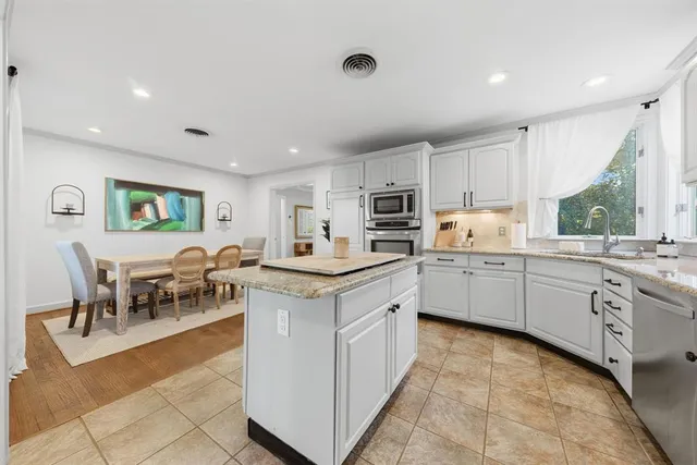a kitchen with appliances a sink a counter top space and a center island