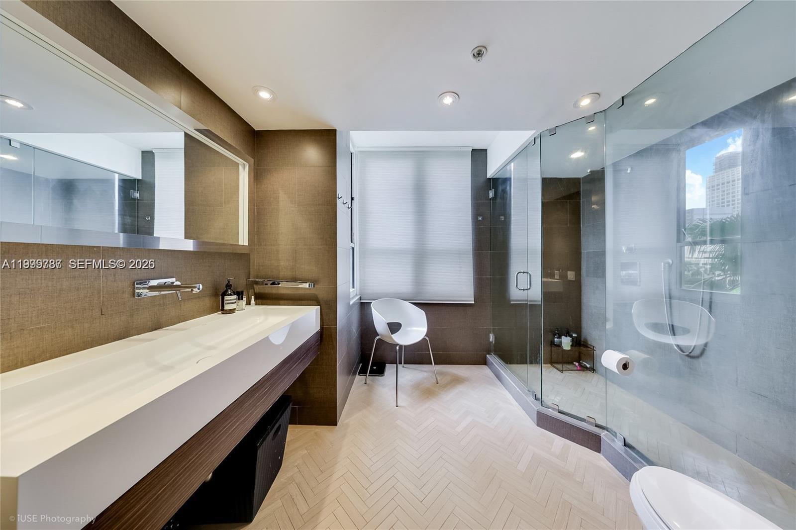 701 Brickell Key Boulevard, Unit 503 Miami, FL 33131 - Photo 11 of 25 a bathroom with a double vanity sink and mirror with shower