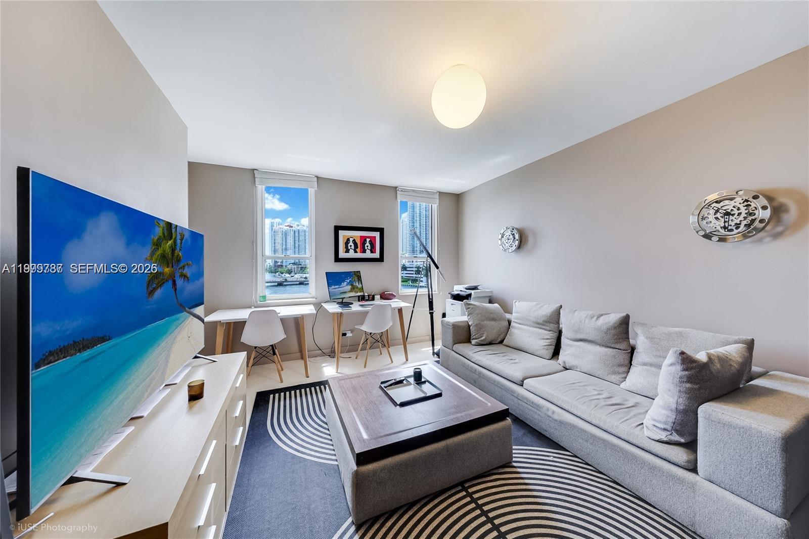 701 Brickell Key Boulevard, Unit 503 Miami, FL 33131 - Photo 5 of 25 a living room with furniture and a flat screen tv