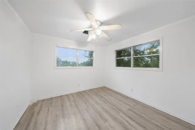 an empty room with a window and a fan