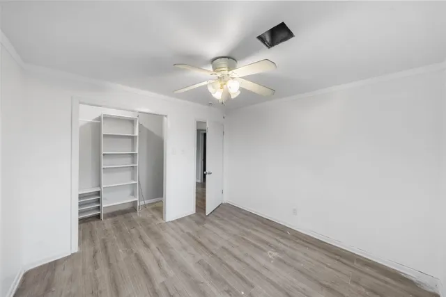 an empty room with a ceiling fan and wooden floor