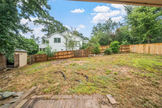 a view of a yard with wooden fence