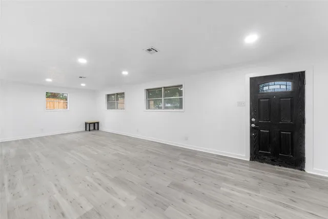 a view of an empty room with wooden floor and closet