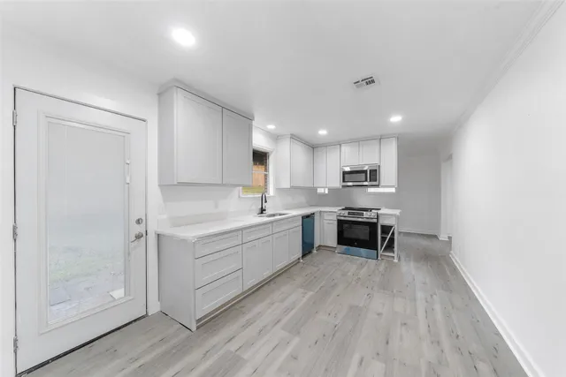 a large kitchen with a lot of counter space and a wooden floors