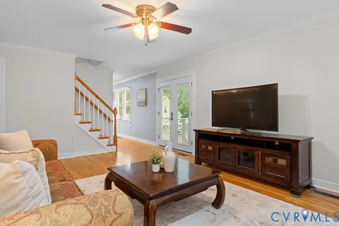 a kitchen with granite countertop a refrigerator oven a sink dishwasher and white cabinets with wooden floor