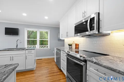 a kitchen with granite countertop a sink and a stove top oven