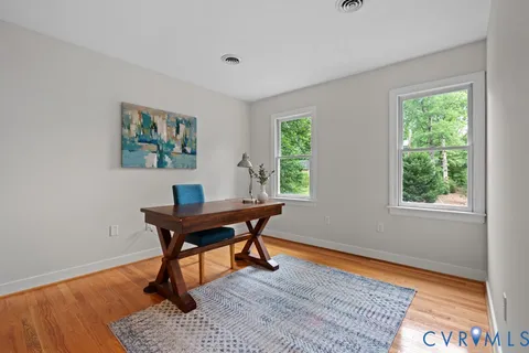 a bathroom with a toilet a sink a mirror a window and vanity