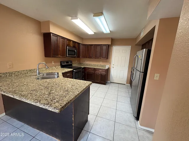 a kitchen with stainless steel appliances granite countertop a refrigerator oven a sink and dishwasher