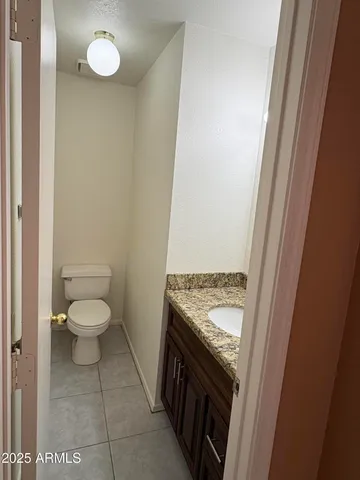 a bathroom with a granite countertop toilet and a sink