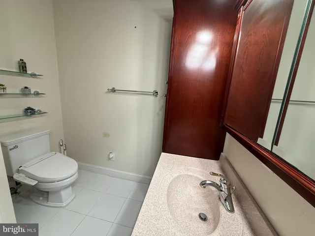 a bathroom with a sink and mirror with toilet