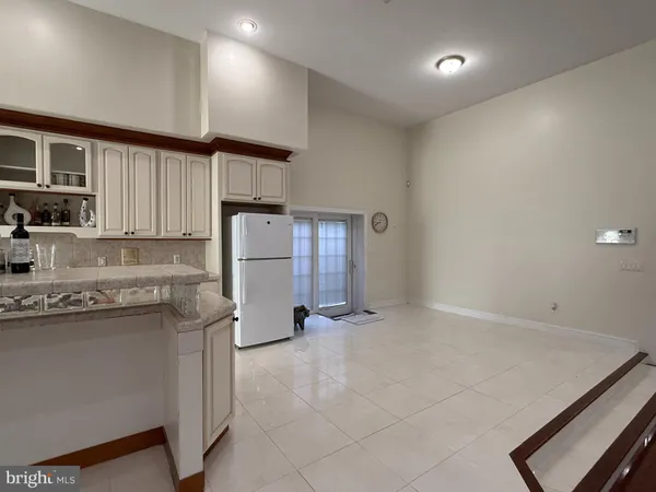 a kitchen with a sink a refrigerator and cabinets