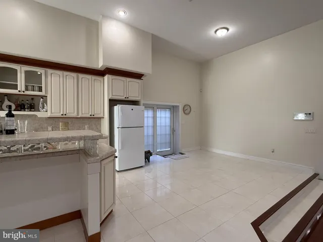 a kitchen with a sink a refrigerator and cabinets