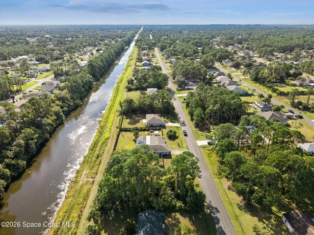 an aerial view of residential houses with outdoor space and swimming pool