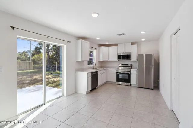 a kitchen with stainless steel appliances a refrigerator sink and cabinets