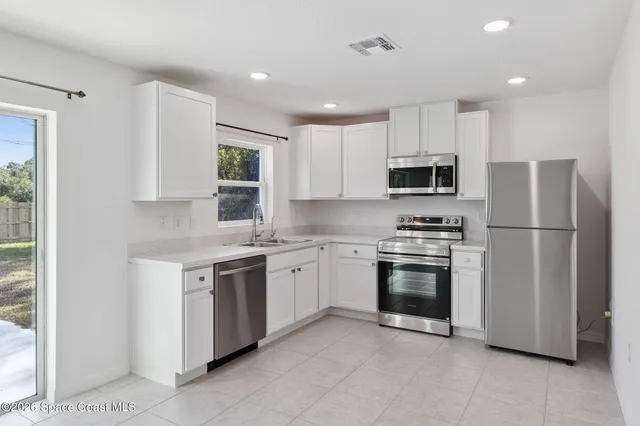 a kitchen with stainless steel appliances granite countertop a refrigerator stove a sink and a microwave