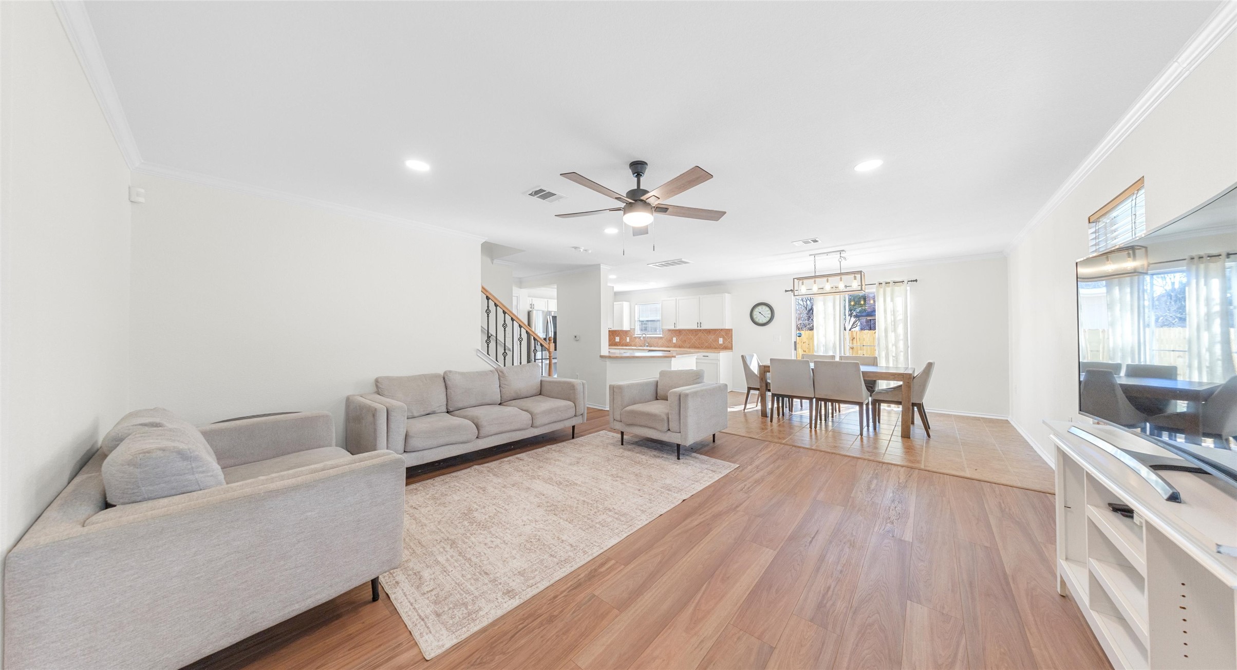 Living room featuring ceiling fan, light wood-style floors, ornamental molding, and recessed lighting