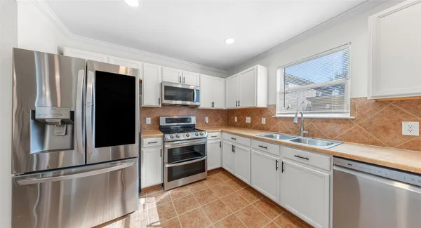 a kitchen with granite countertop stainless steel appliances and white cabinets