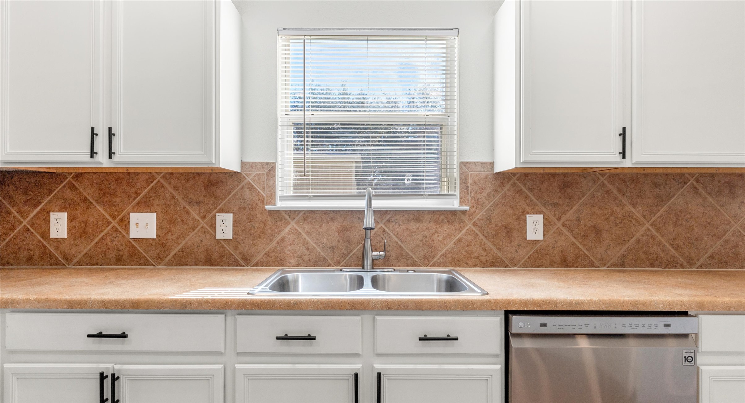 8613 Wiley Way Austin, TX 78747 - Photo 13 of 33 Kitchen featuring white cabinetry, stainless steel dishwasher, and light countertops