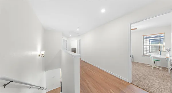 a view of hallway with wooden floor