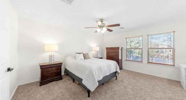 a bedroom with a bed a chandelier and a window