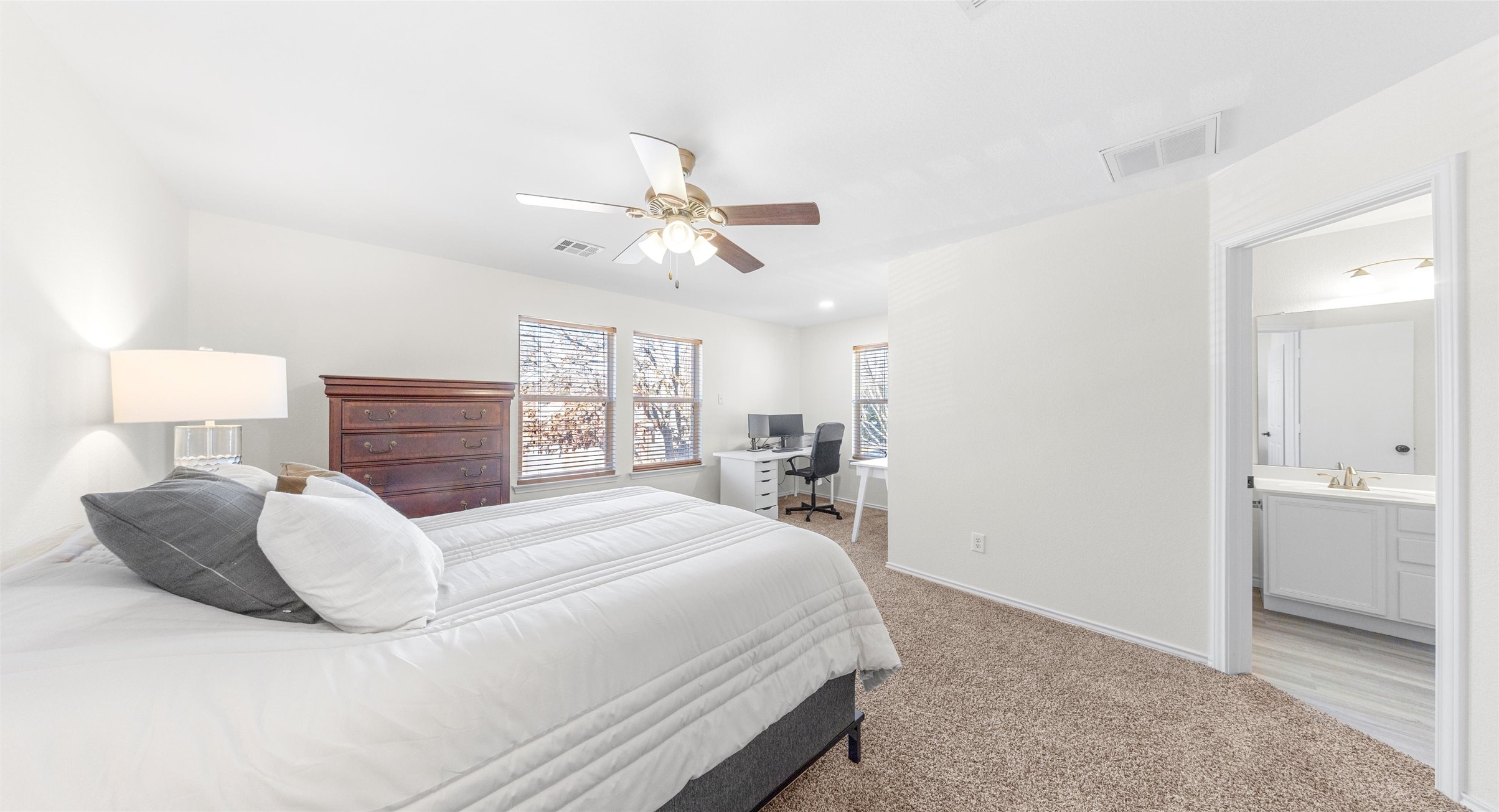 8613 Wiley Way Austin, TX 78747 - Photo 18 of 33 Bedroom with an office area, light colored carpet, ceiling fan, and ensuite bath