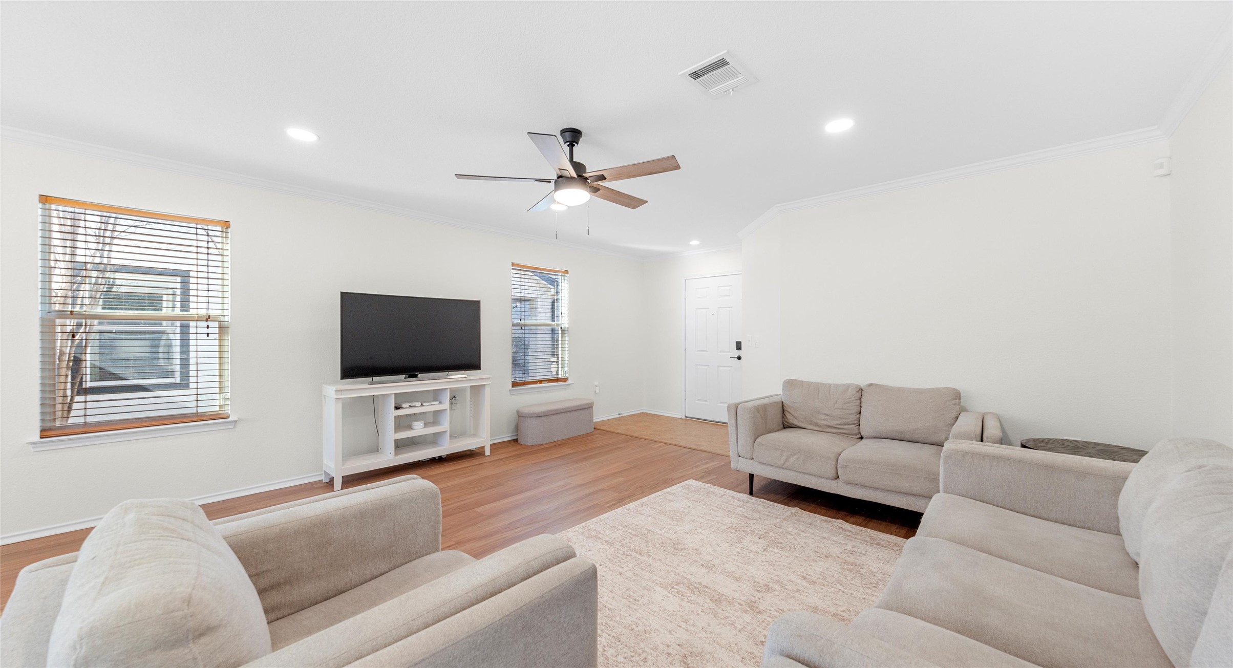 8613 Wiley Way Austin, TX 78747 - Photo 2 of 33 Living room featuring wood finished floors, ornamental molding, ceiling fan, and recessed lighting