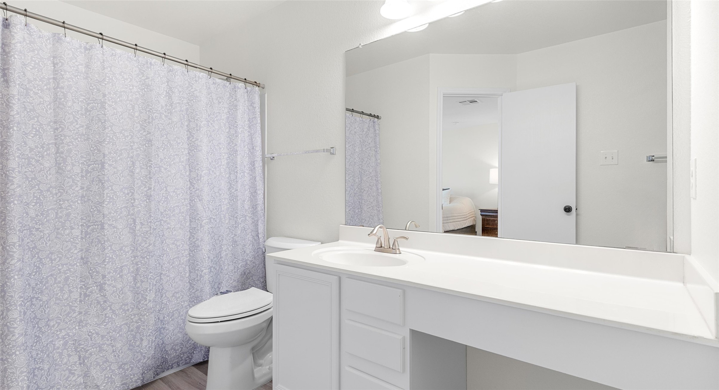 8613 Wiley Way Austin, TX 78747 - Photo 23 of 33 Bathroom featuring vanity, a shower with shower curtain, light wood-type flooring, and ensuite bathroom