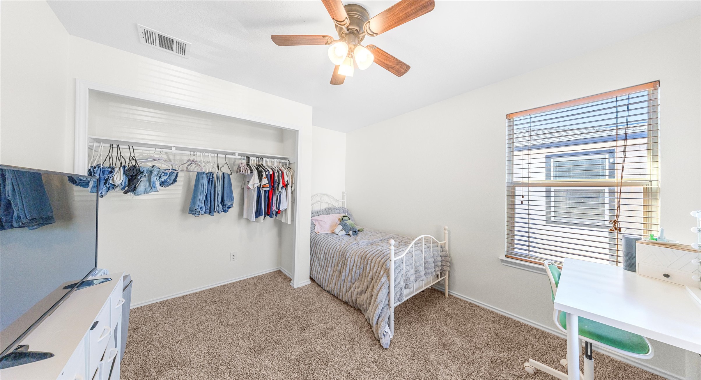 8613 Wiley Way Austin, TX 78747 - Photo 27 of 33 Bedroom with multiple windows, ceiling fan, light colored carpet, and a closet