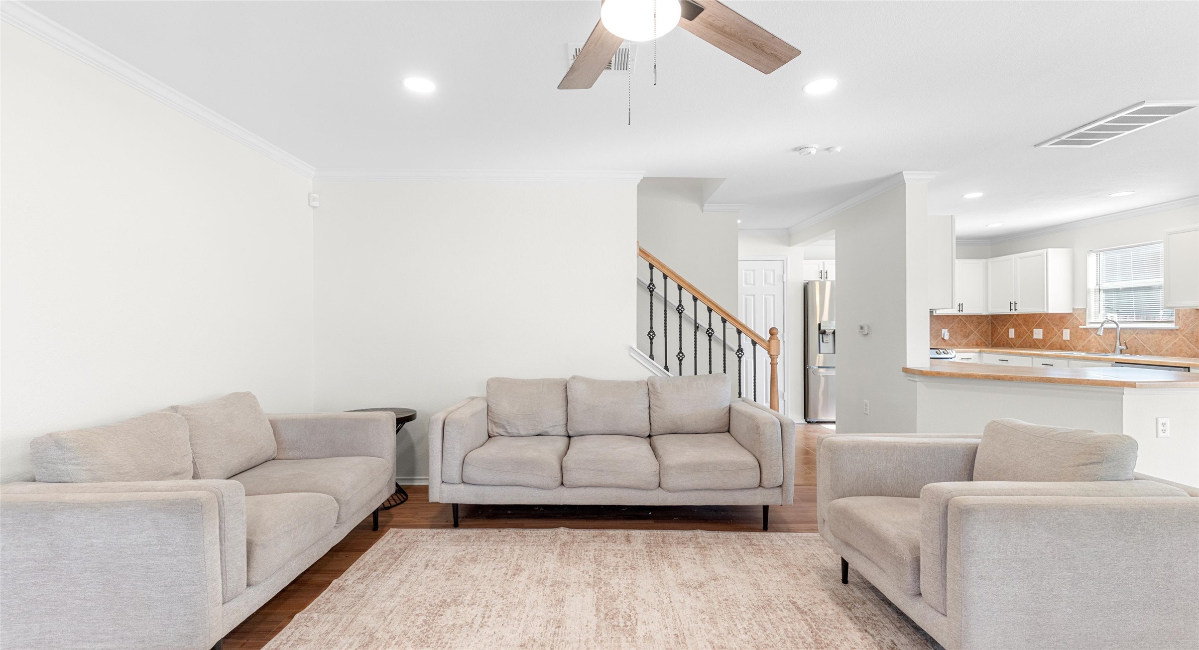 8613 Wiley Way Austin, TX 78747 - Photo 3 of 33 Living area with a ceiling fan, ornamental molding, wood finished floors, and recessed lighting