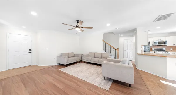 a living room with furniture and a wooden floor