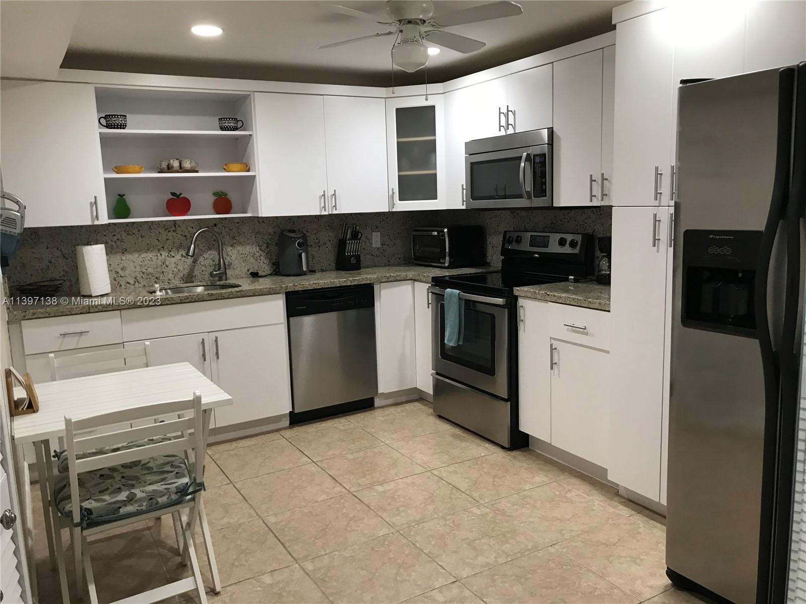 Bonaventure Weston, FL 33326 - Photo 8 of 14 a kitchen with stainless steel appliances granite countertop a stove top oven microwave and refrigerator