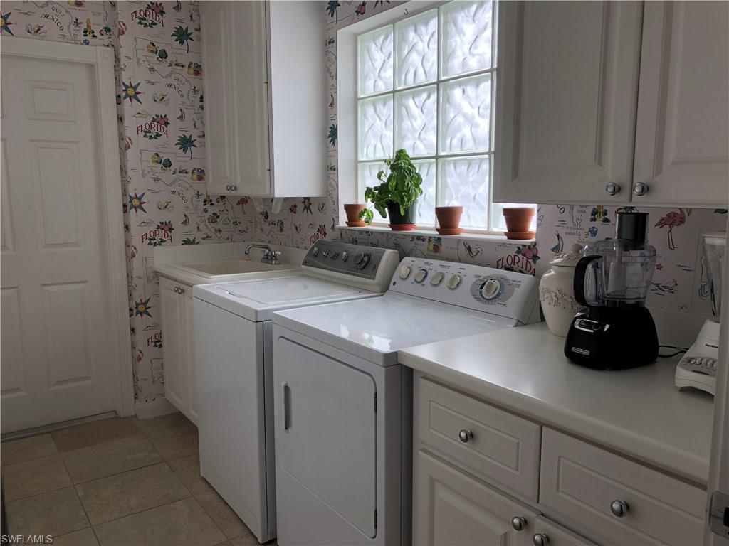 7640 Rozzini Lane Naples, FL 34114 - Photo 13 of 17 a view of bathroom with a sink a window and cabinets