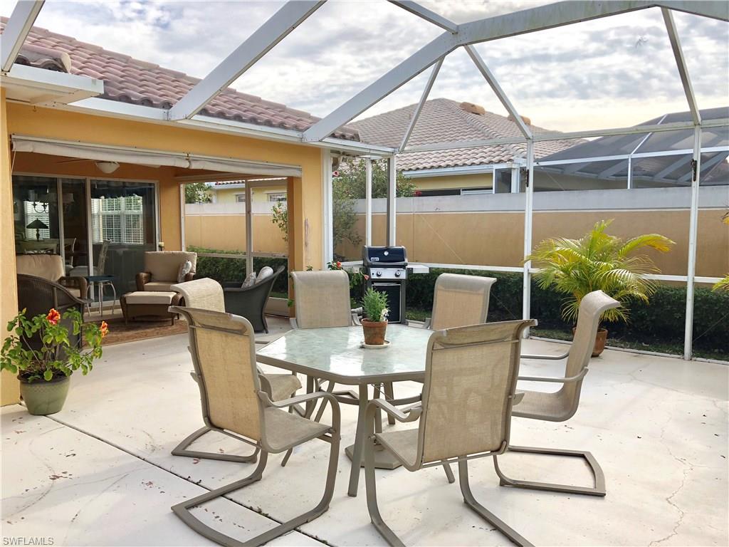 7640 Rozzini Lane Naples, FL 34114 - Photo 14 of 17 a dining room with furniture a chandelier and glass door