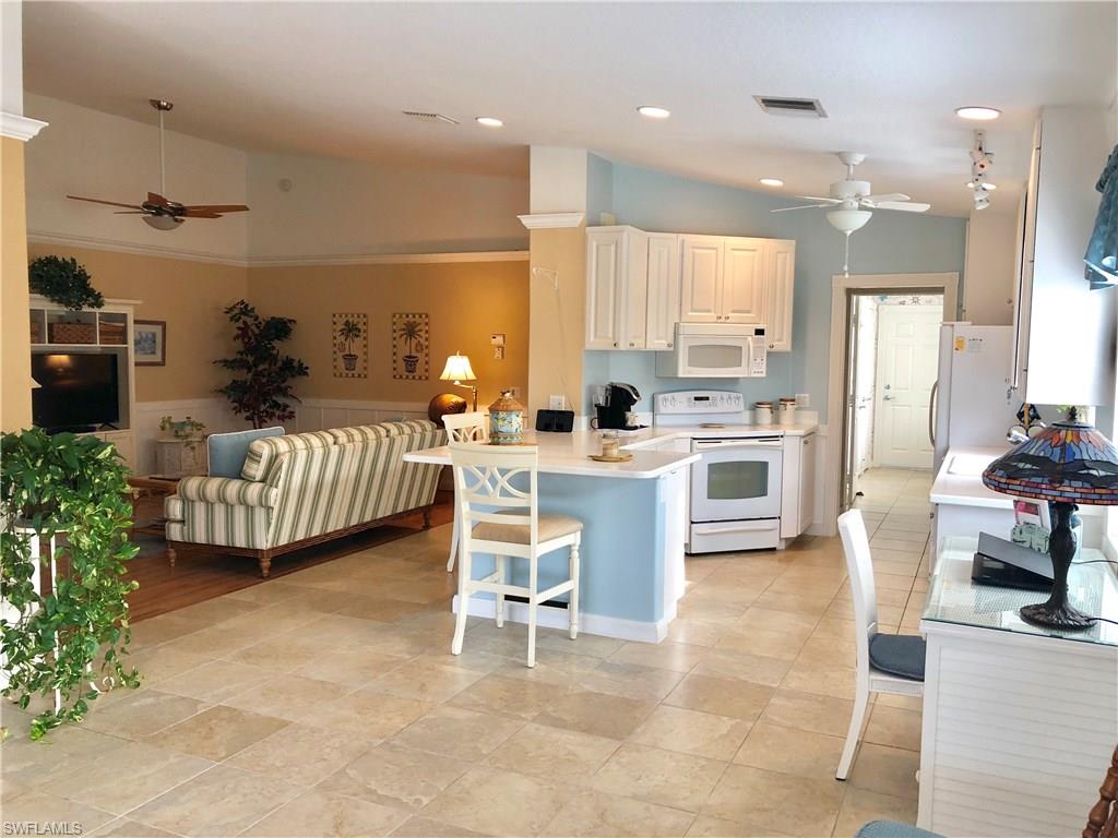 7640 Rozzini Lane Naples, FL 34114 - Photo 7 of 17 a kitchen with kitchen island granite countertop lots of counter top space and appliances