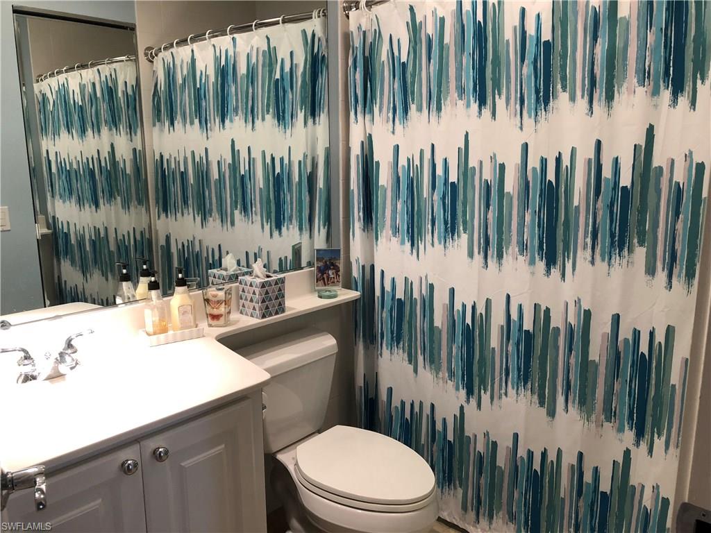 7640 Rozzini Lane Naples, FL 34114 - Photo 9 of 17 a bathroom with a toilet a sink and mirror