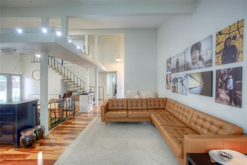 12231 Veronica Road Farmers Branch, TX 75234 - Photo 6 of 26 Open concept living area featuring high ceilings, wood-finish flooring, a contemporary staircase with metal railings, and dual French doors leading to an exterior space