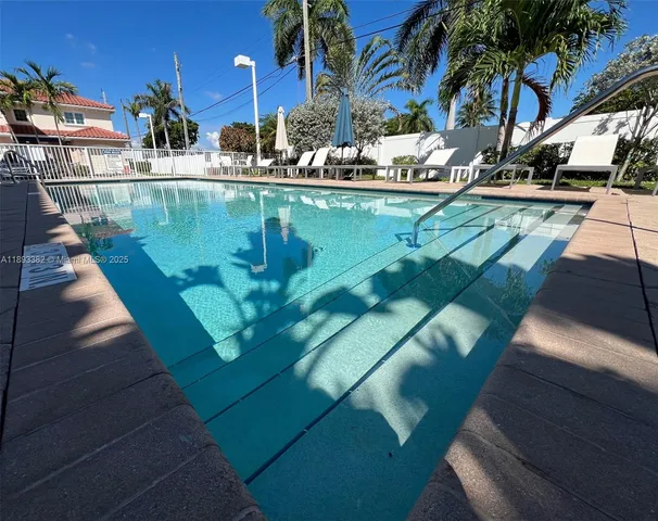 a view of a swimming pool with a patio and plants