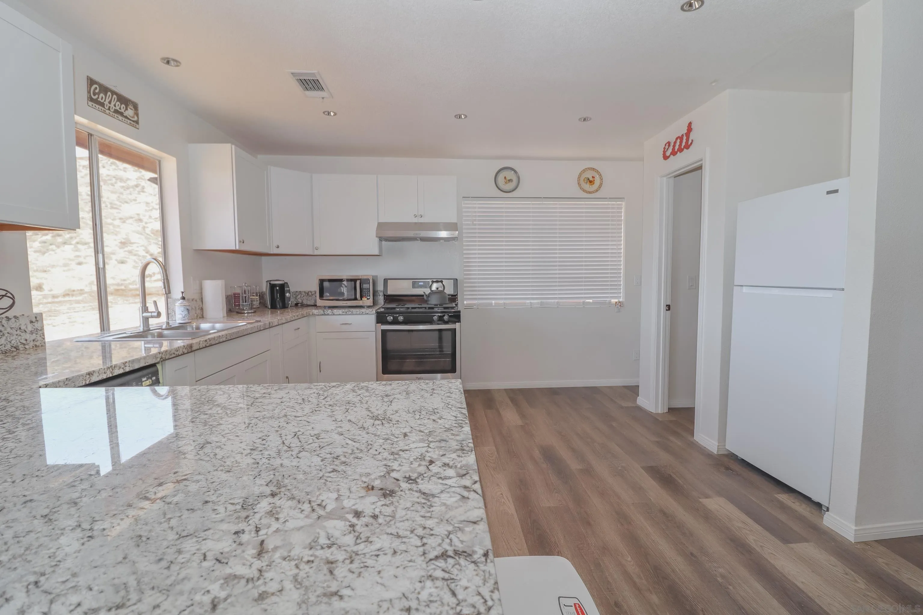 21141 Sharp Road Perris, CA 92570 - Photo 5 of 43 a kitchen with granite countertop a refrigerator and a sink