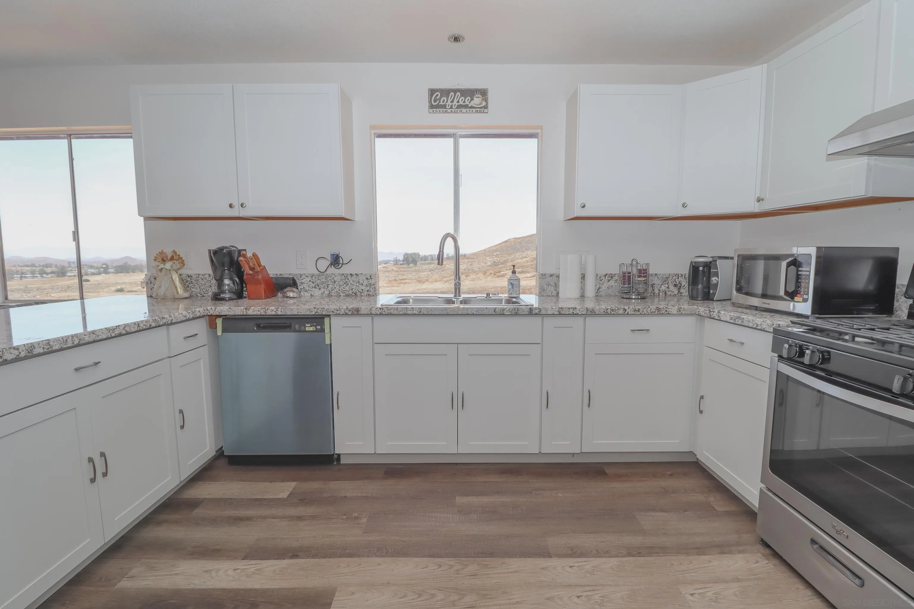 21141 Sharp Road Perris, CA 92570 - Photo 6 of 43 a kitchen with white cabinets appliances a sink and a window