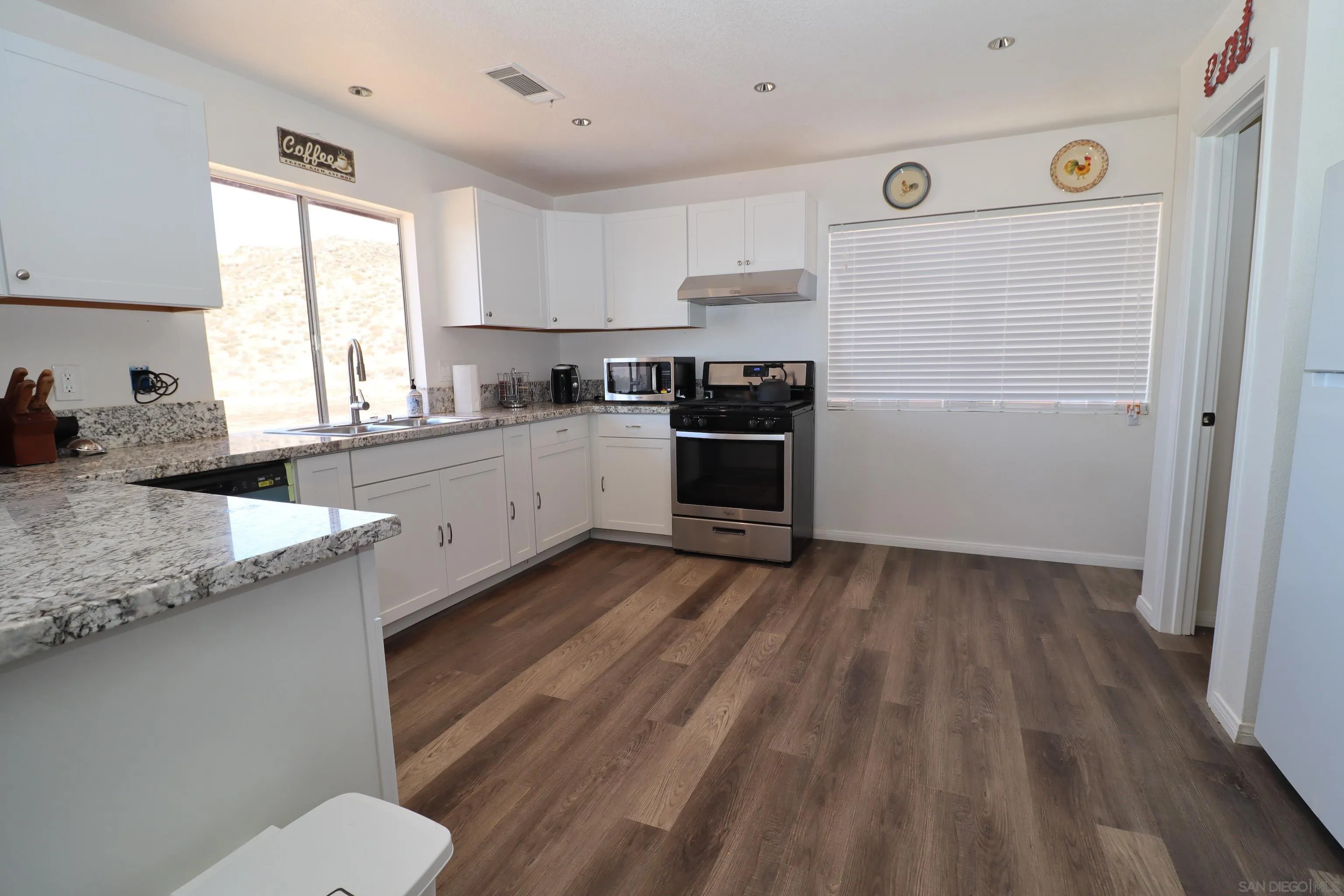 21141 Sharp Road Perris, CA 92570 - Photo 7 of 43 a kitchen with granite countertop white cabinets and white appliances