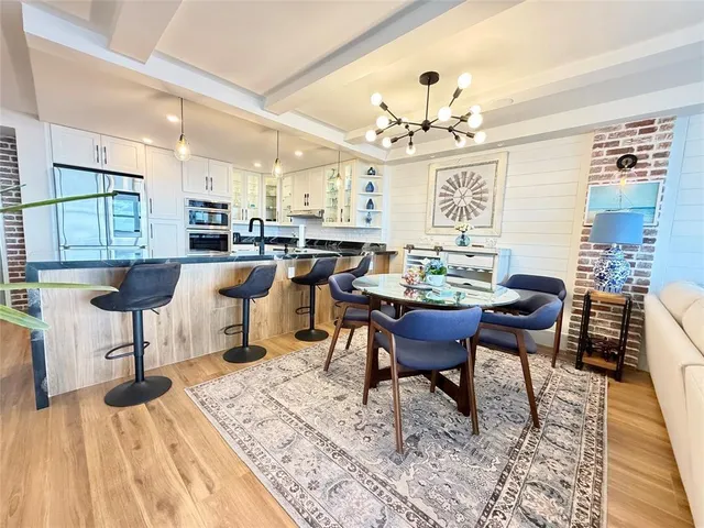 a view of a dining room with furniture a chandelier and wooden floor