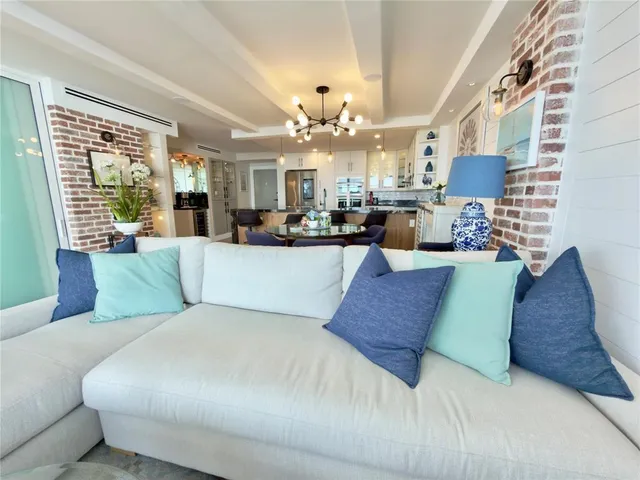 a living room with furniture chandelier and a large window