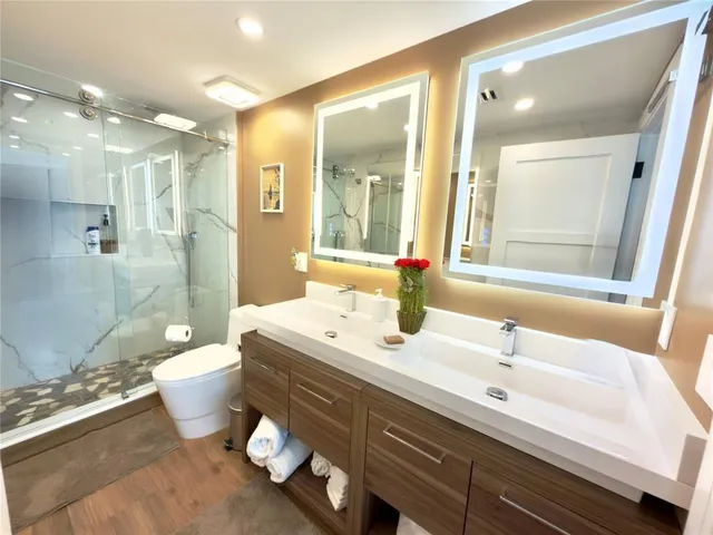 a bathroom with a double vanity sink mirror and toilet